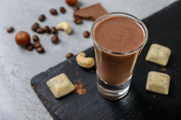 chocolate milk smoothie with  nuts   and coffee beans on grey background