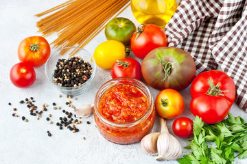 Tomato sauce in  glass jar and ingredients, selective focus
