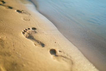 Human footprints close-up on the sandy beach, selective focus