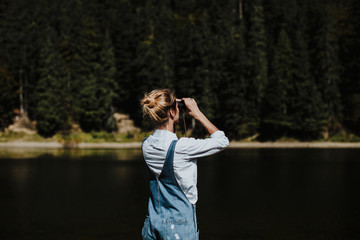 The girl on the lake. Looking through binoculars