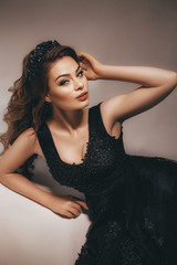 Portrait of beautiful young woman with makeup in black dress