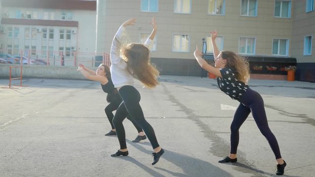 The dance team arranged a performance on the street. Young girls perform emotional dance.