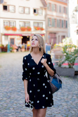 Fototapeta premium Young style girl in black dress walking down the street in Strasbourg, France, Autumn season time