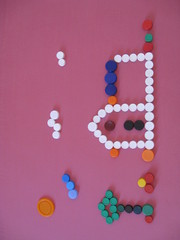 Paisaje tipo infantil con casa, árbol, nubes de tapones plástico para enseñar a niños a reciclar, fondo rosa