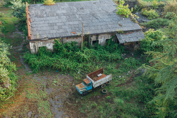 Old rusty truck at abandoned overgrown industrial area. Aerial view