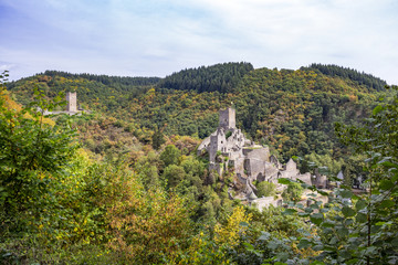Fototapeta na wymiar Autumn panoramic view to the ruins of Oberburg and Niederburg, the Upper and Lower Castle of Manderscheid, Germany as seen from the main street