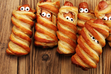Mummy sausages scary halloween party food decoration wrapped in dough.