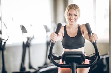 Woman exercising on machine together.Attractive builder muscles women in fitness gym