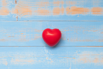 Top view red heart shape on blue pastel color wooden background. Heath care, Love and Valentine Day Concepts