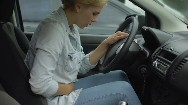 Woman in casual clothes suffering from stomachache and taking painkillers
