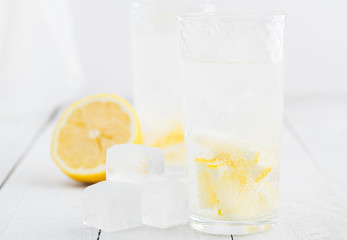 Lemon juice detox water. Mineral water infused with lemons. Wooden white table.