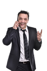 Young man wearing a a dark suit, white shirt and black tie, smiling holding a smart phone and a briefcase, isolated on white background.