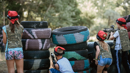 Kids playing lasertag on special polygon with shelter