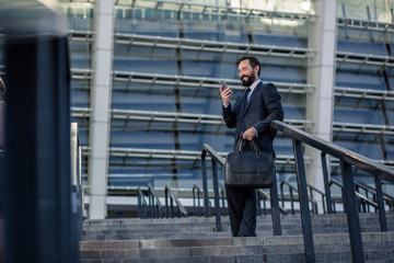 Full length of a cheerful businessman using his phone