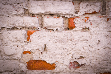 old vintage brick wall with shabby white paint background. vignette, architecture, texture.