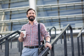 Optimistic handsome man walking down the stairs