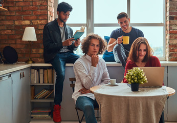 Kitchen in student dormitory. Group of interracial students engaged in education.