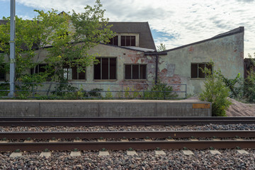 Fototapeta na wymiar Abandoned building by the railroad