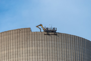 Demolition of the atomic chimney. Remote controlled excavator with shears works from above.
