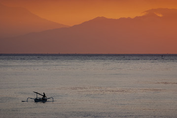 Balinese Fishermen Returning to Shore in Amed, Bali. After a night of fishing for mackerel in the Indian Ocean a fisherman in a sailing vessel called a "jukung" returns to shore with his catch.