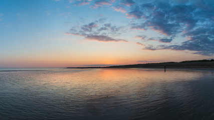 Fototapeta na wymiar Beautiful vibrant Summer sunset beach landscape with stunning sky and colors