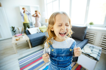 Youthful daughter crying and screaming loudly while being naughty with her shocked parents on background - obrazy, fototapety, plakaty