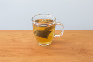 Cup of nettle tea on a wooden table.