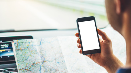 Hipster man looking on navigation map in car, tourist traveler driving and holding in male hands...