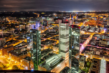 Fototapeta na wymiar Die Hochhauskulisse von Frankfurt am Main am Abend bei künstlicher Beleuchtung