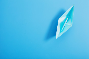 paper boat on blue paper background