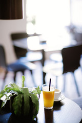 Glass of juice and cup of coffee on a table at restaurant