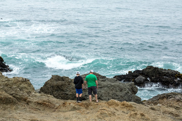 Tourists climbing rocks that lead to the beach