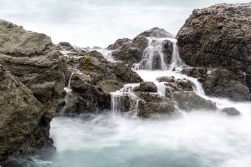 Long exposure of surf washed rocks on a foggy day