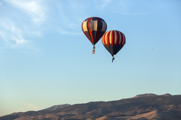 Fototapeta na wymiar American flag and Nevada state flag flying with hot air balloons