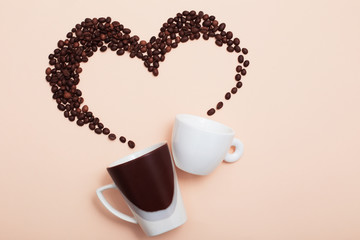 two cups with coffee beans on light background