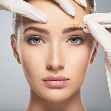  woman getting cosmetic botox injection in forehead