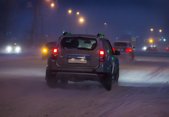 Fototapeta na wymiar Cars drive along snow-covered road.
