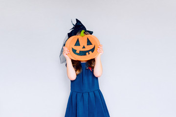 girl holding a terrible pumpkin.  concept of the fall holidays of Halloween. tradition of the...