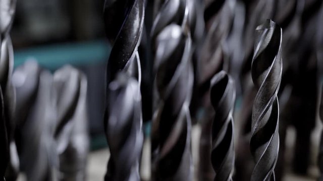 metal drill bits different sizes are standing in a workshop, camera is showing it, moving along