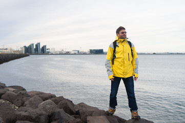 inspired man on sea beach in reykjavik, iceland. Man traveler smile and looking in future on sea shore. freedom sence. vacation with travelling and wanderlust. man feel inspired in reykjavik, iceland