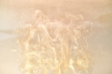 golden paint in water abstract background with waves. shiny particles spread out