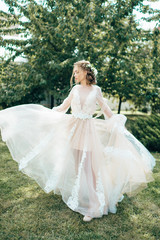 Bride in a long dress on a green background. Bright photo of a beautiful girl