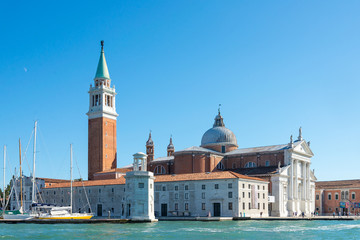 Fototapeta na wymiar View of Church of San Giorgio Maggiore and Fondazione Giorgio Cini are located on one island of Venice, Italy. Palladio Venice architectures and parking yacht on island at Venice.