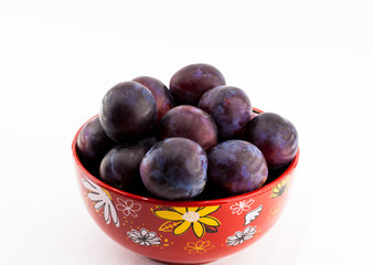 Fruit plum on a plate on a white background isolated close-up