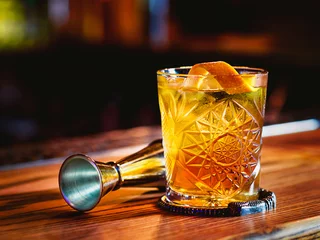 Foto op Plexiglas Ouderwetse cocktail en beker op de toog © k8most