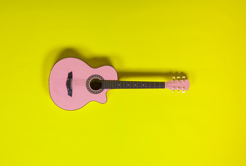 pink guitar on a yellow background