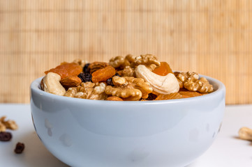 Mixed nuts and fruits in a white bowl