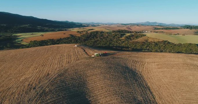 Aerial image of a wheat plantation with working tractor, drone scene