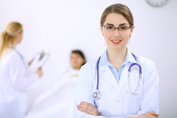 Fototapeta premium Female doctor smiling on the background with patient and his doctor