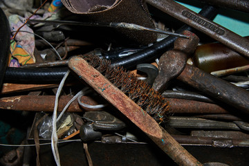 Rusty Metal brush and hammer on the workbench with rusty wrenches made in USSR on the background